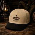 Tan 5 panel cap with embroidered Nail & Crown Co. nail and crown of thorns logo on rustic wood surface with vintage lantern