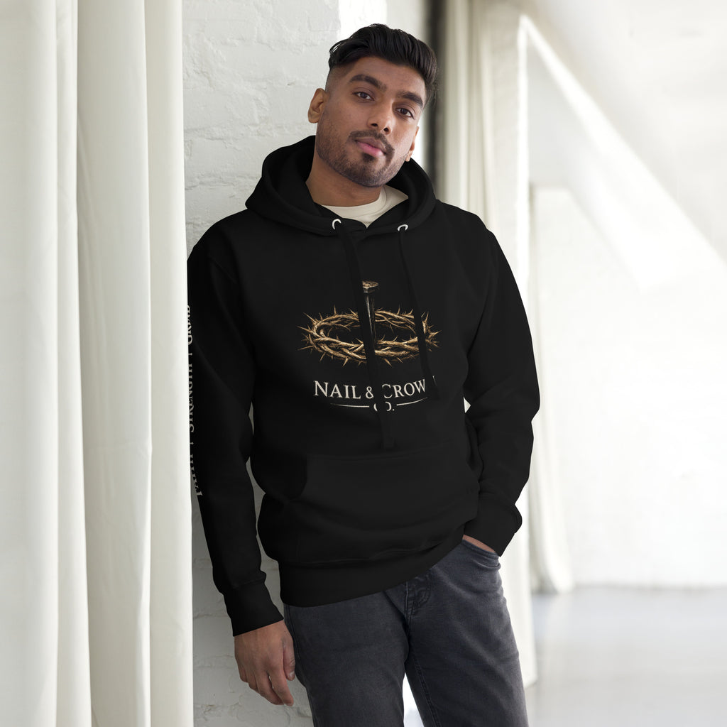 Man wearing Nail & Crown Co. Black Unisex Pullover Hoodie — Faith Strength Grind Christian Streetwear