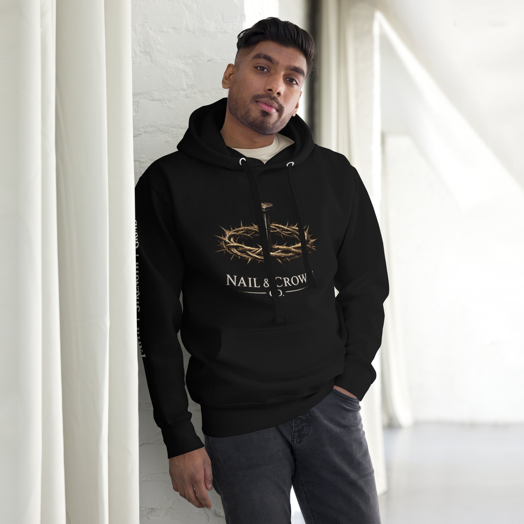 Man wearing Nail & Crown Co. Black Unisex Pullover Hoodie — Faith Strength Grind Christian Streetwear